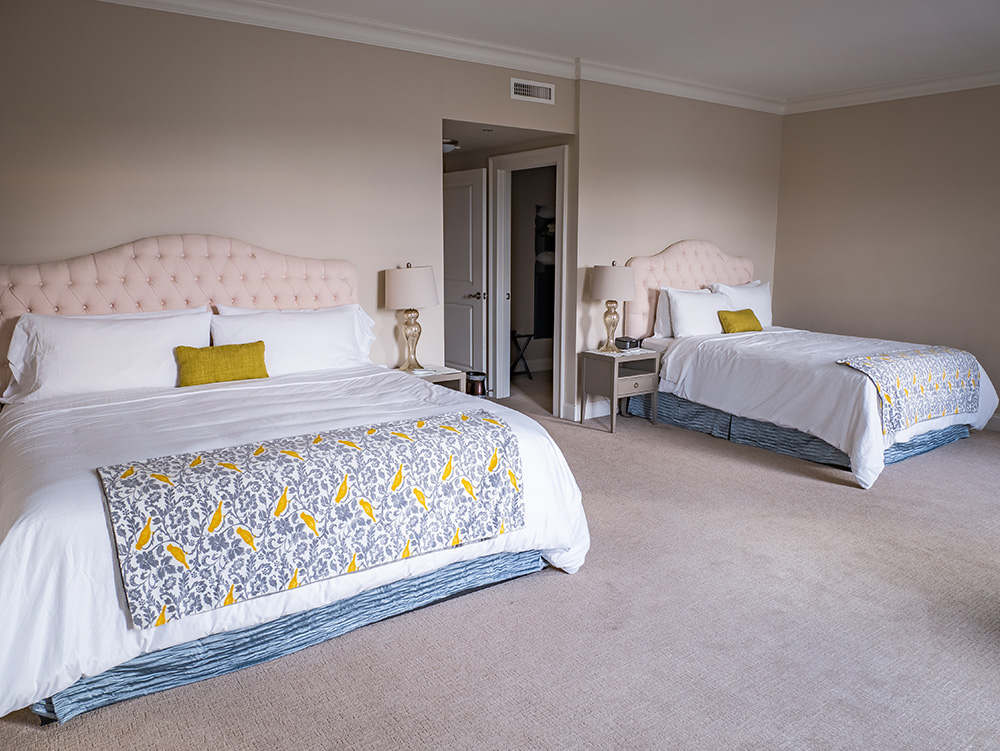 A Mantissa suite dressed for arrival: layered linens, soft bedside light, and considered detailing.