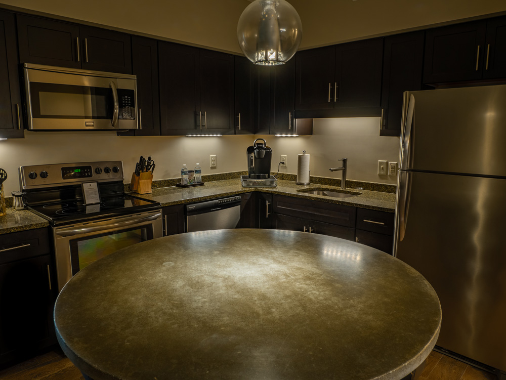 A full kitchen inside a Mantissa suite, with counter space and cabinetry for a longer stay