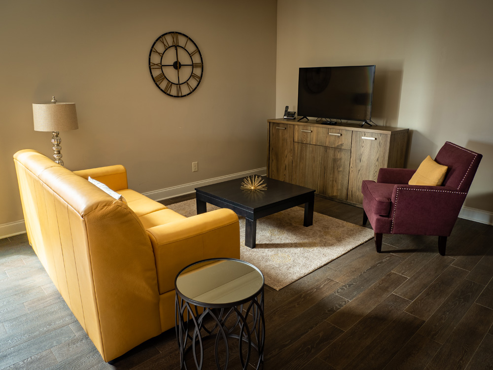 A residential Mantissa suite interior with warm wood, soft textiles, and a marble surface