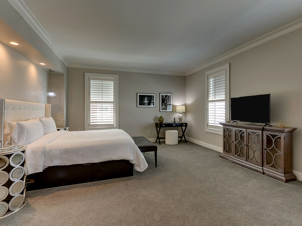 A Mantissa suite with a king bed, living area, and plantation shutters