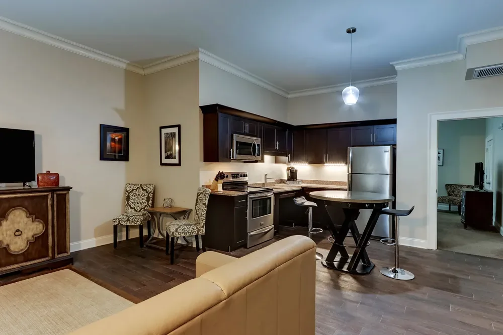 The Accessible King's full kitchen with lowered counters, a high-top table, and the living room beyond.