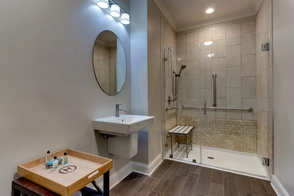The Accessible King's ADA bath: a roll-under sink, grab rails, and a curbless roll-in shower with a bench.