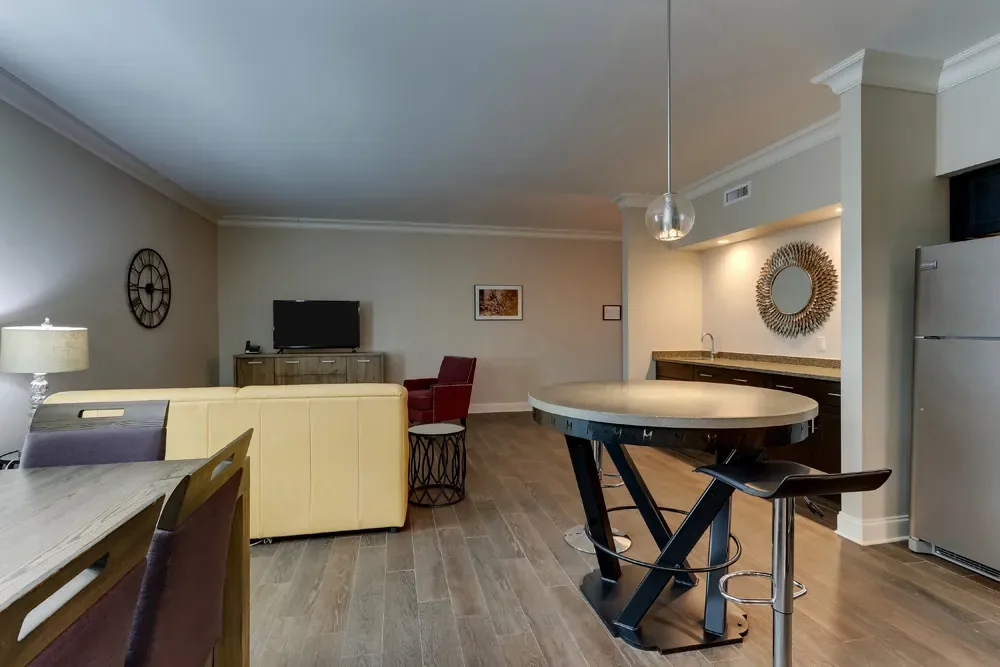 The long main room of the Deluxe King, from the writing desk past the sofa and high-top table to the full kitchen.